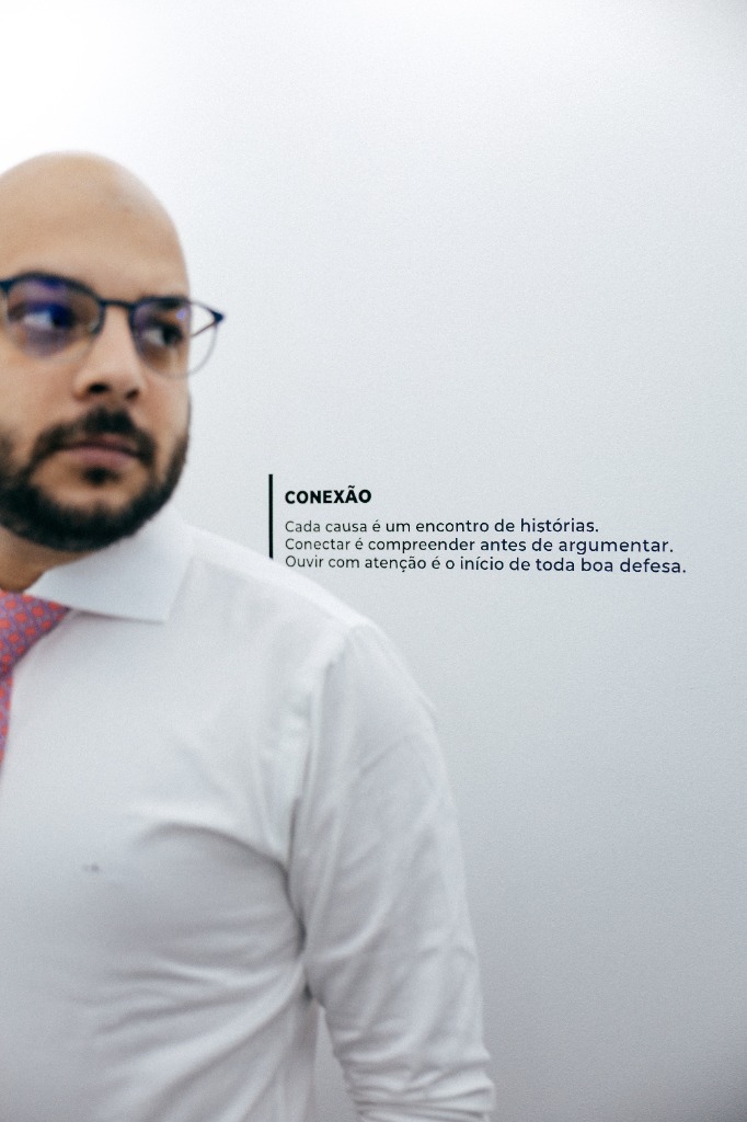 Leonardo Sampaio diante da parede com o texto Conexão, no escritório em Eunápolis