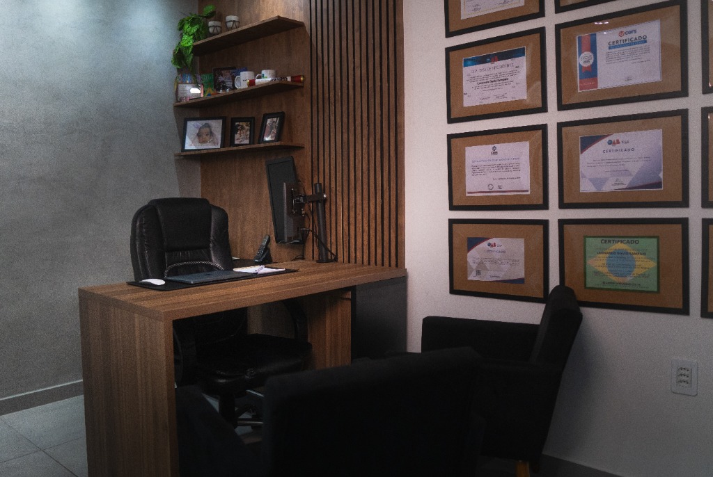 Sala de reuniões do escritório de advocacia em Eunápolis, com mesa e televisor